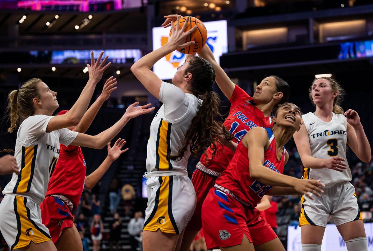 Oak Ridge Trojans’ Ella Ray (30), center, pulls in an defensive rebound ahead of reaching Folsom Bulldog Kamryn Mafua (14), to her right, and over Jada Tupou (23) during the second period of the high school girls basketball Sac-Joaquin Section Division I championship game Saturday, Feb. 26, 2022, at Golden 1 Center in Sacramento. Oak Ridge edged past Folsom, 41-40, for the section title.