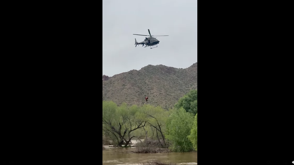 A kayaker held onto tree branches along a raging river in Arizona as a rescue helicopter hovered overhead and prepared to hoist him up out of the violent waters, reports say.