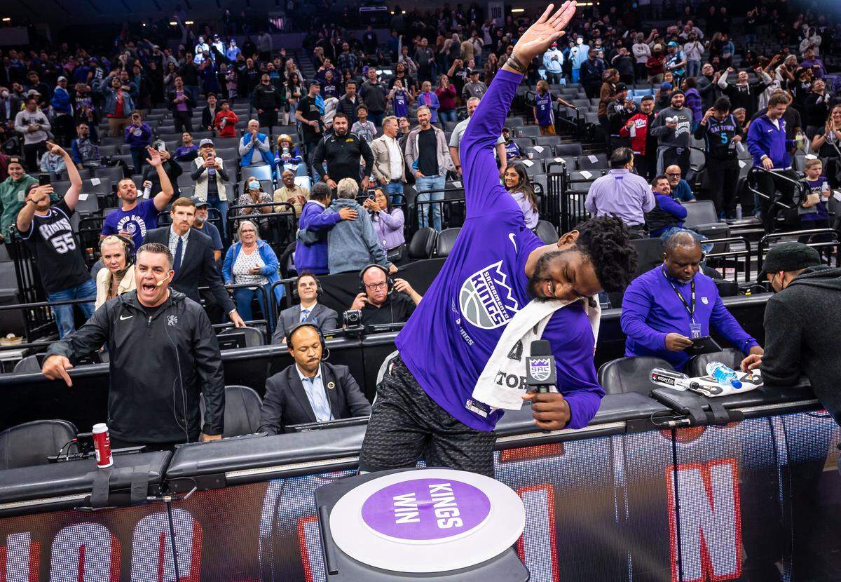 Sacramento Kings center Chimezie Metu (7) raises his hand to swing down on a "button" to light the team's victory beam in the sky above the area after their 130-112 win over the San Antonio Spurs on Nov. 17, 2022, at Golden 1 Center. It’s the first time The Bee photographed the indoor beam ceremony, which has evolved over time. 