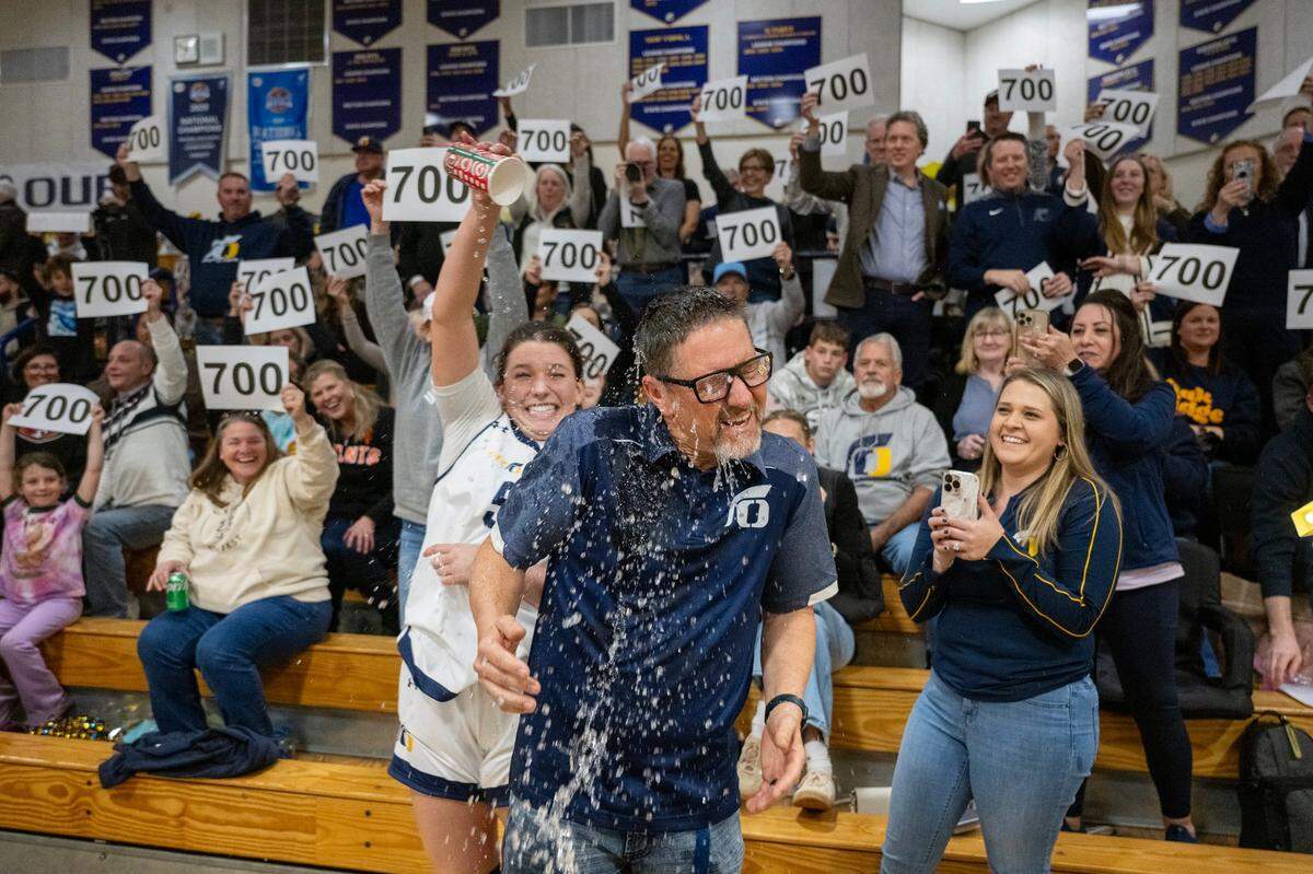 The Oak Ridge Trojans’ Sofia Williams (5) douses head coach Stephen White with water following the team’s 64-27 victory, White’s 700th win as a head coach, on Feb. 7 in El Dorado Hills.