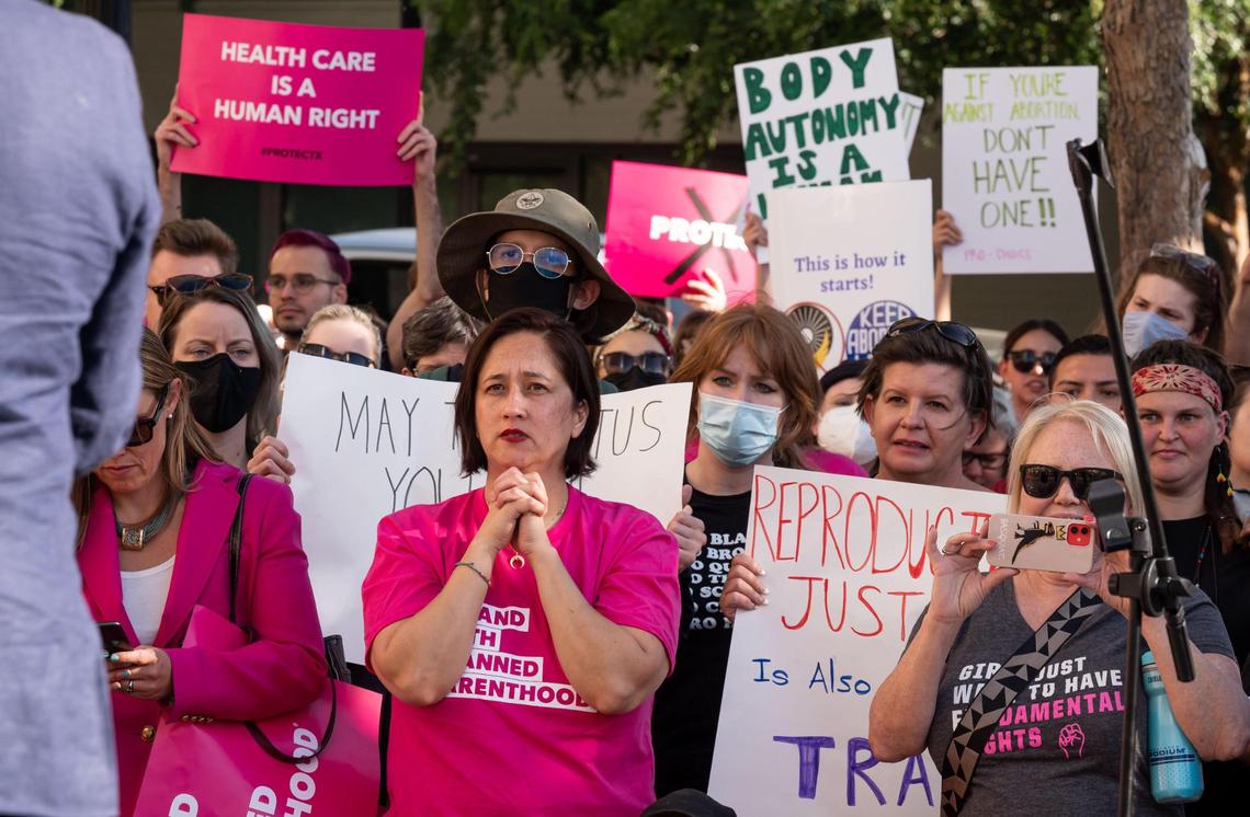 Nikki Ragsac with Planned Parenthood Affiliates of California, clasps her hands as she listens to policymakers speak outside the federal courthouse in downtown Sacramento on May 3. Gov. Gavin Newsom is planning to provide more than $50 million in additional funds to help further expand access to abortion care in California.