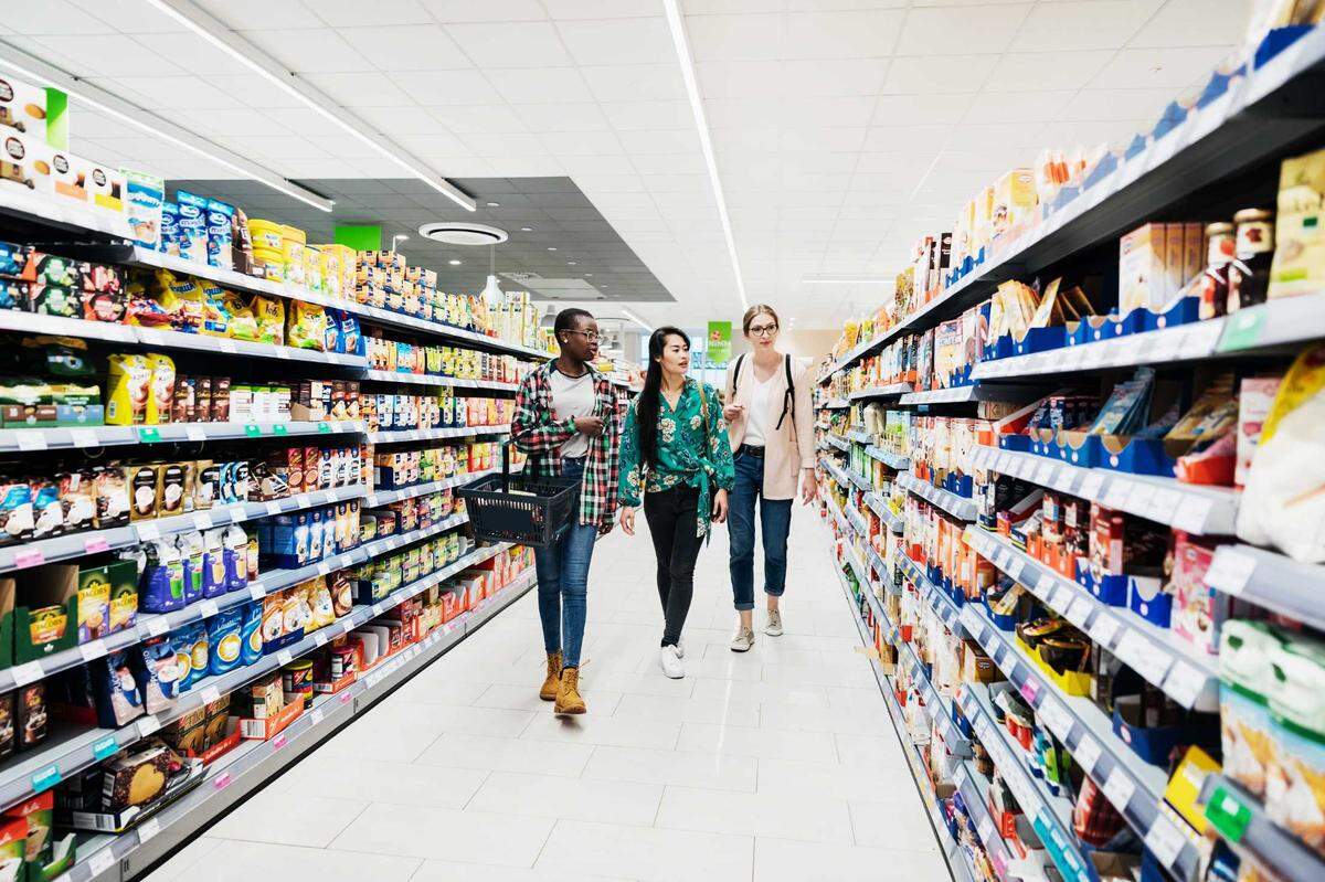 Three women shopping at a grocery store.