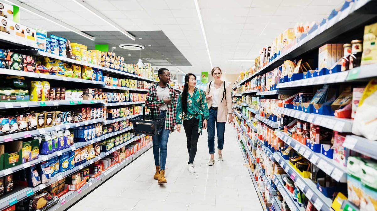 Three women shopping at a grocery store.