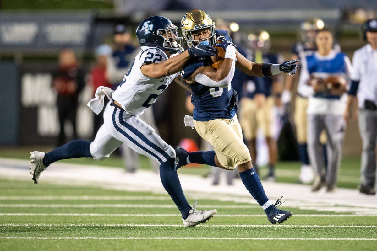 UC Davis Aggies running back Ulonzo Gilliam Jr. (34) gets a first down before being taken out of bounds by San Diego Toreros safety Maverick Martin (22) during the first quarter of the NCAA college football game Saturday, Sept. 17, 2022, at the Aggies’ home opener at UC Davis Health Stadium.