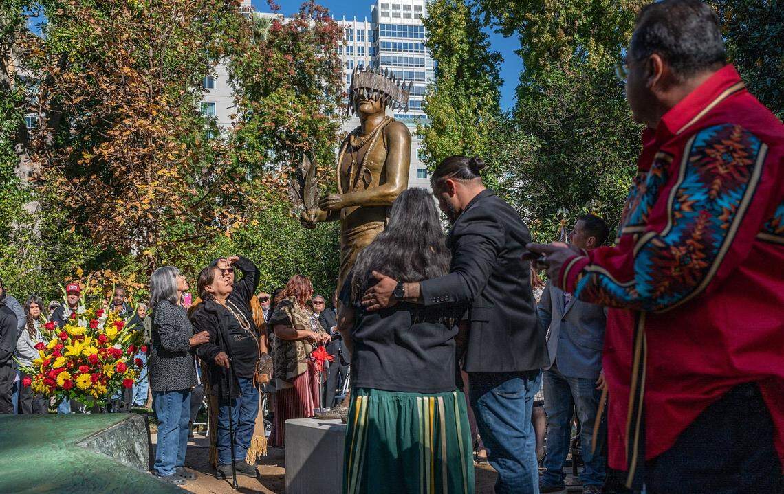 Marjorie, left, and Sally Franklin, daughters of William J. Franklin Sr., look at the statue in his likeness during the unveiling and dedication of the California Native American Monument at Capitol Park in Sacramento on Tuesday. Franklin was a Miwok Native American leader and cultural preservationist who promoted native culture through dance.
