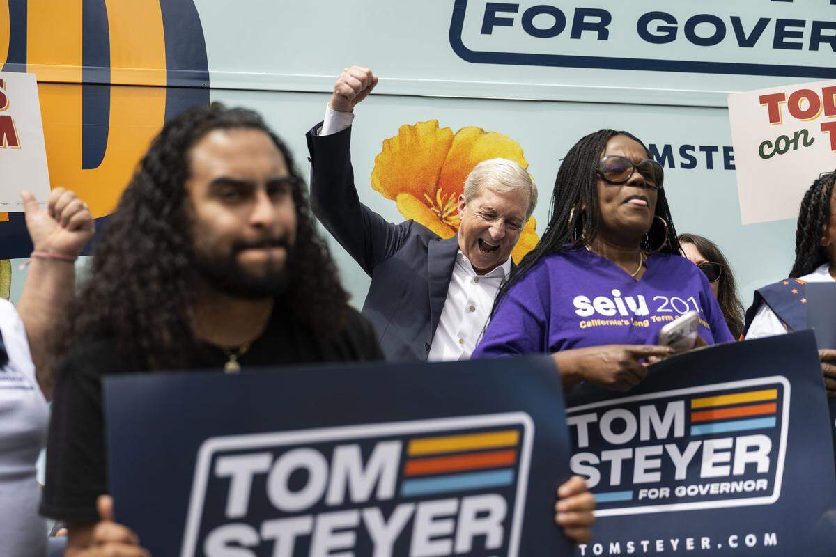 Gubernatorial candidate Tom Steyer chants with supporters during a bus tour stop at the SEIU 2015 office in West Sacramento on Friday.