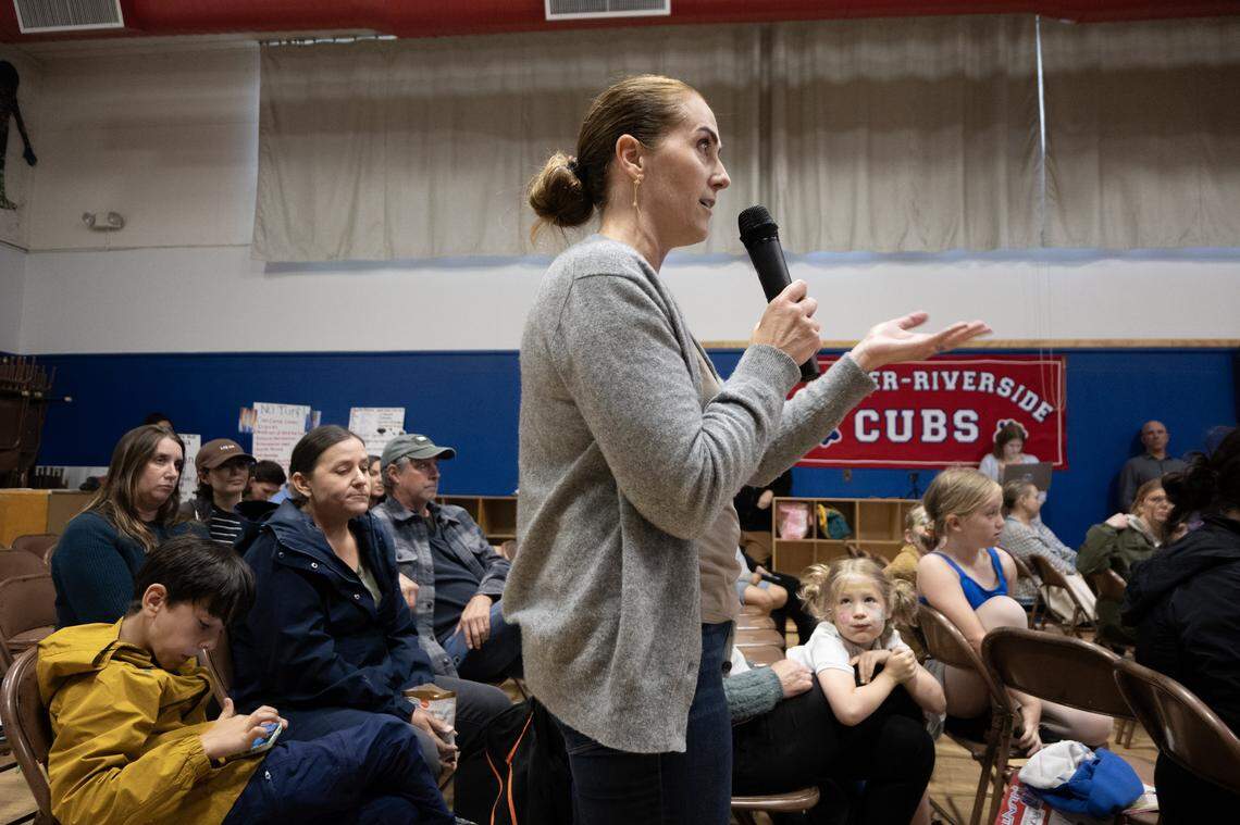 Tiffany McFarland Olcese voices her concern about replacing the existing grass field at Crocker/Riverside Elementary School with artificial turf during a community meeting at the school on Tuesday.