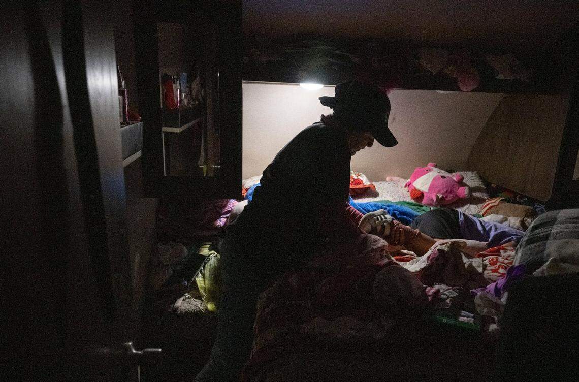 Sayda, 44, a Yolo County farmworker who is among the many workers in California living with anxiety because of their immigration status, dresses her daughter before leaving to work in the fields before dawn earlier this month. Sayda immigrated from Honduras with a young son 15 years ago.