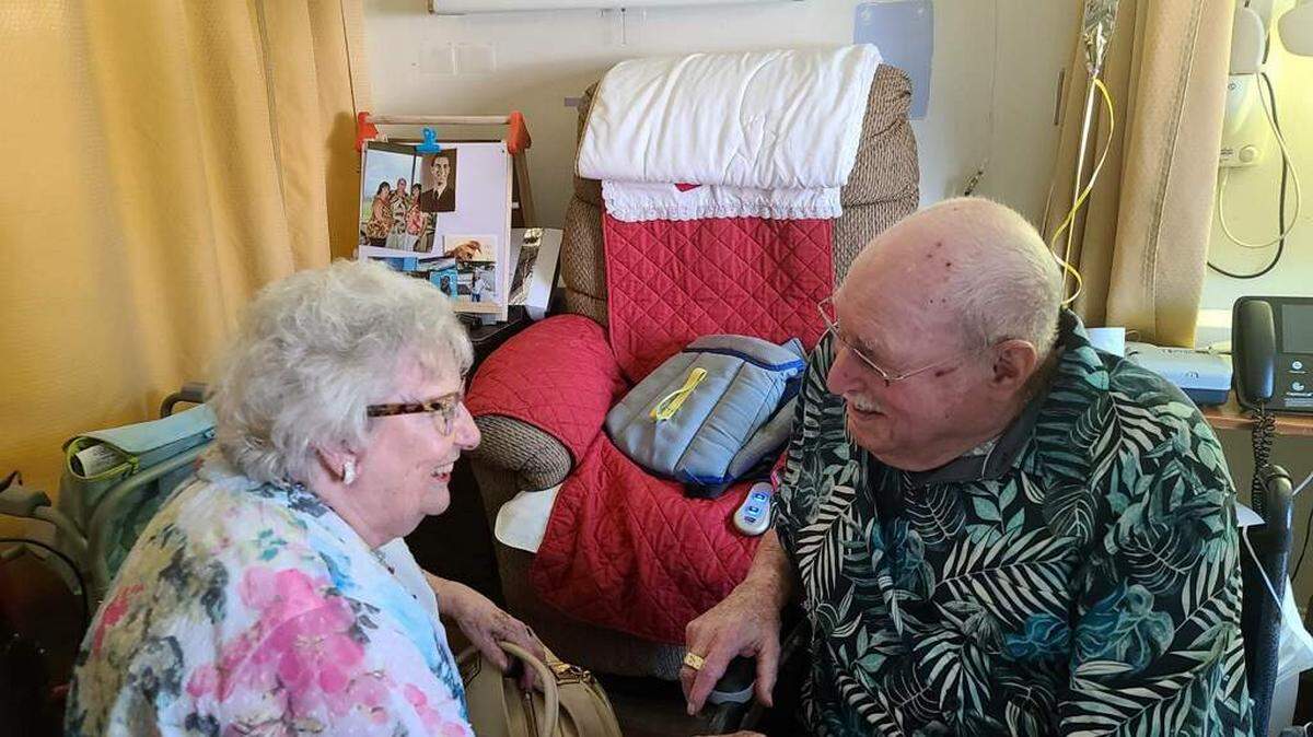 Bonnie Alexander, left, holds hands with Clyde Behr, right.