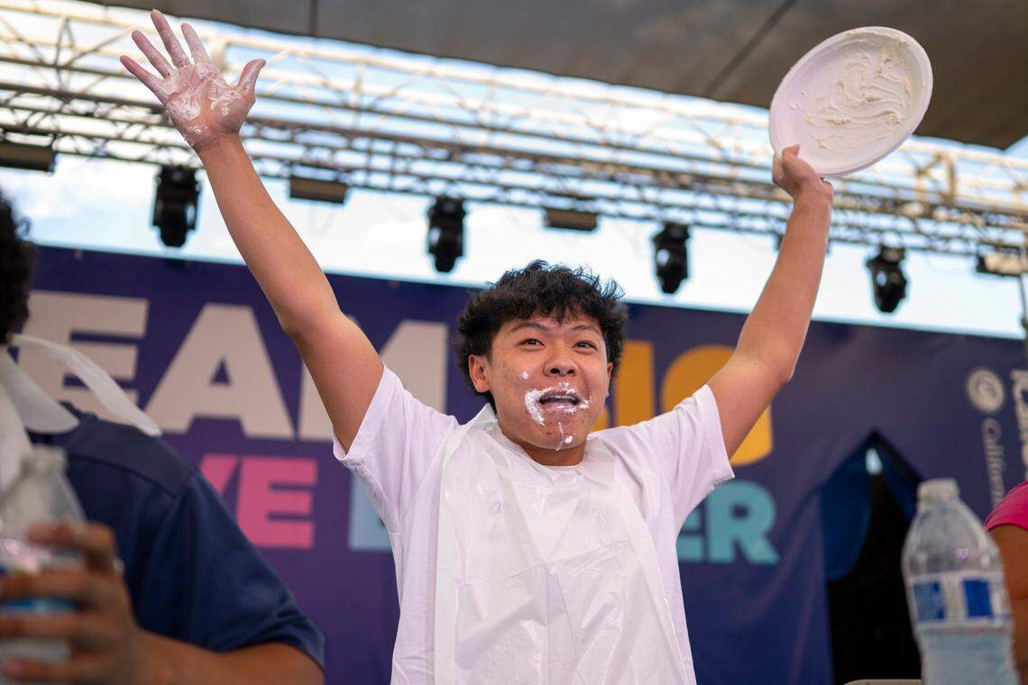 Jason Wong raises his hands in celebration after winning first place in the teen division of the pie eating contest at the California State Fair in Sacramento on Monday, July 21, 2025. 
