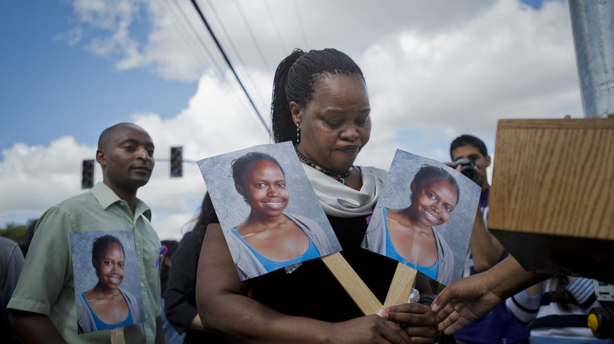 Mary Murigi carries pictures of her daughter Michelle on May 9, 2014. Michelle was killed crossing the street near her school. Since her death, the City Council pledged to end deadly crashes with “Vision Zero,” but has made little progress toward that goal.