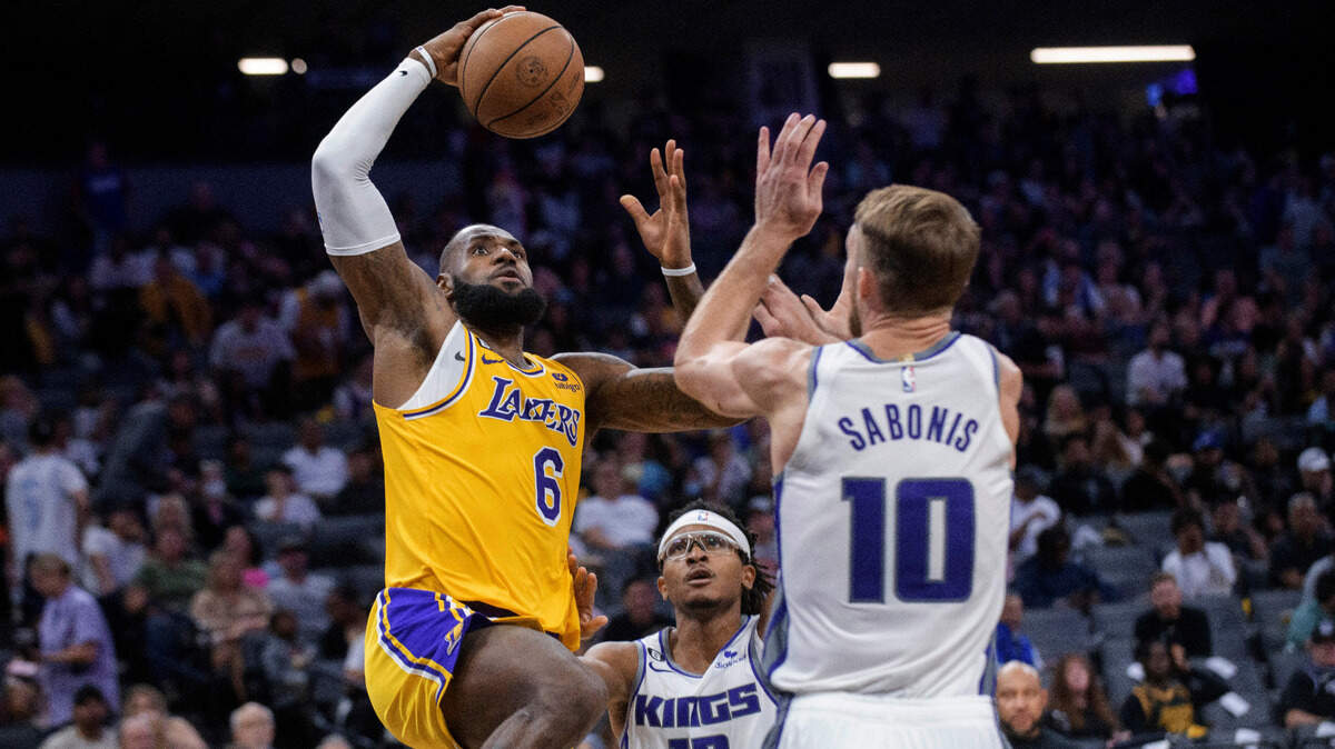 Los Angeles Lakers forward LeBron James (6) drives to the basket past Sacramento Kings forward Chima Moneke (19) and forward Domantas Sabonis (10) during the second half of a preseason NBA basketball game in Sacramento, Calif., Friday, Oct. 14, 2022. The Kings won 133-86. (AP Photo/Randall Benton)