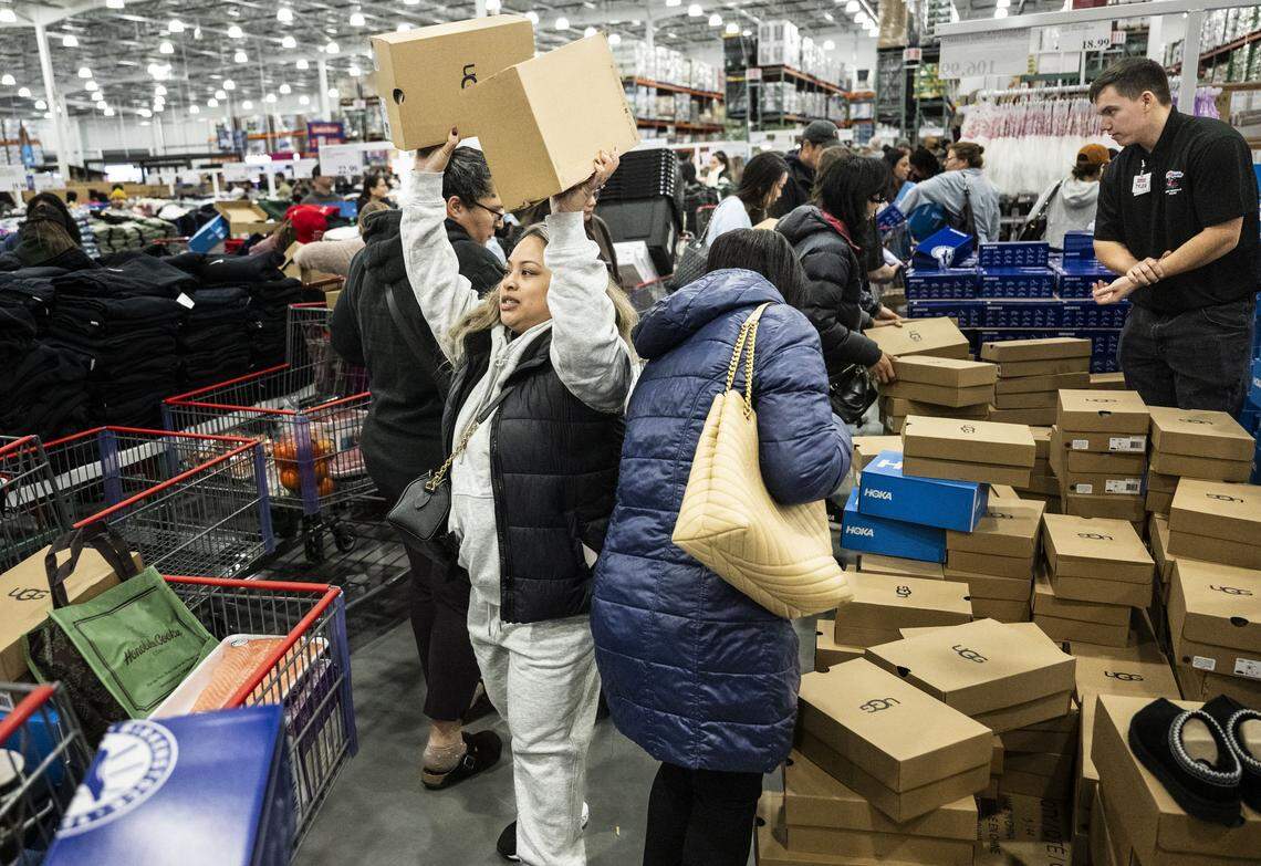 Customer Jaimie Valle, of west Roseville, holds two pairs of Ugg shoes during the grand opening at the Costco on Baseline Road in Roseville on Friday.
