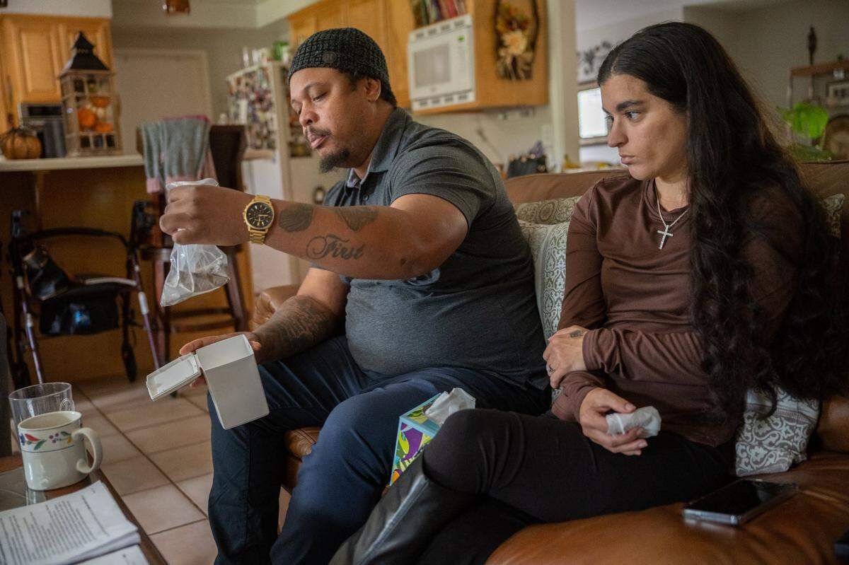 Rachel Harrison watches as her partner Marcell Johnson holds their baby’s ashes last month. “This to me means more than just someone telling me to flush my baby down the toilet,” Johnson said. “At least he can still be with us in some fashion.”