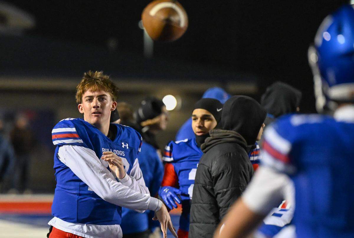 Folsom Bulldogs quarterback Brody Rudnicki (10) warms up on the sideline with wide receiver Rob Larson (1) after the second-half injury to starting quarterback Ryder Lyons against the Riordan Crusaders In a CIF Northern California Regional Division 1-AA football championship game in Folsom on Friday.