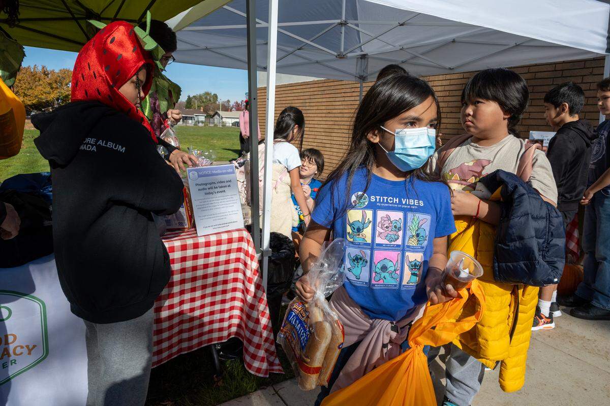 Abigail Gonzalez, 8, leaves with a kit and bread she received from the Food Literacy Center Kitchen on Dec. 1 at John Sloat Elementary School. The Food Literacy Center Kitchen works with the school to provide food and recipes for children to take home and cook. On this day, 50 food kits were distributed.