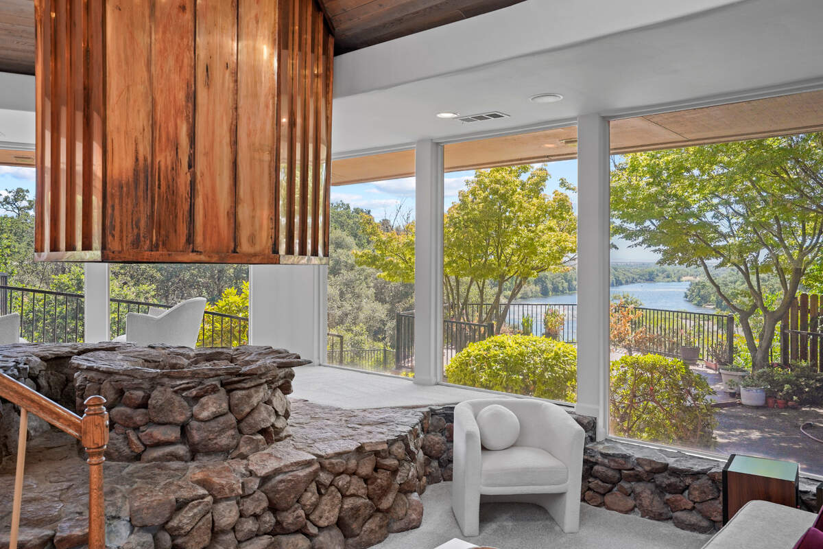 A stone fireplace in a sunken conversation pit with a copper vent in the Sacramento area home for sale for $2.95 million.