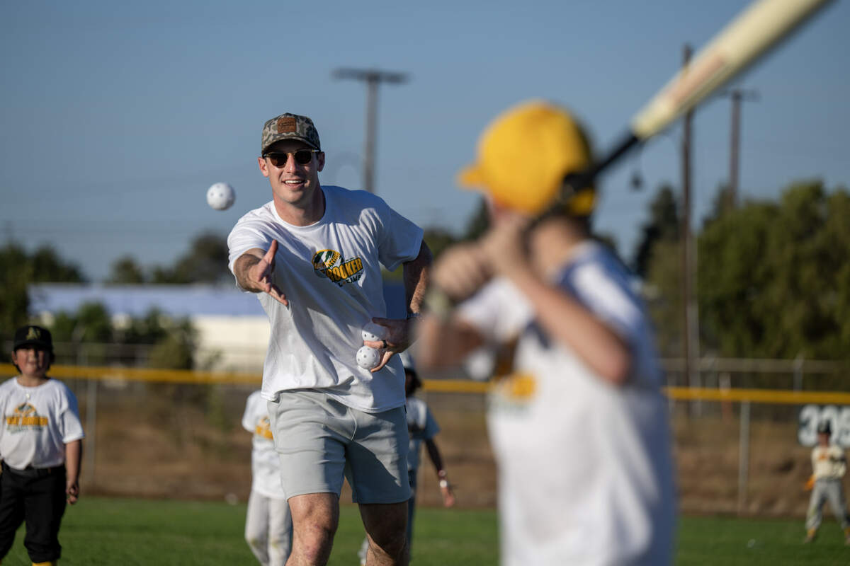 Athletics player Brent Rooker throws soft toss to participants in his youth sports camp Thursday at Depot Park.