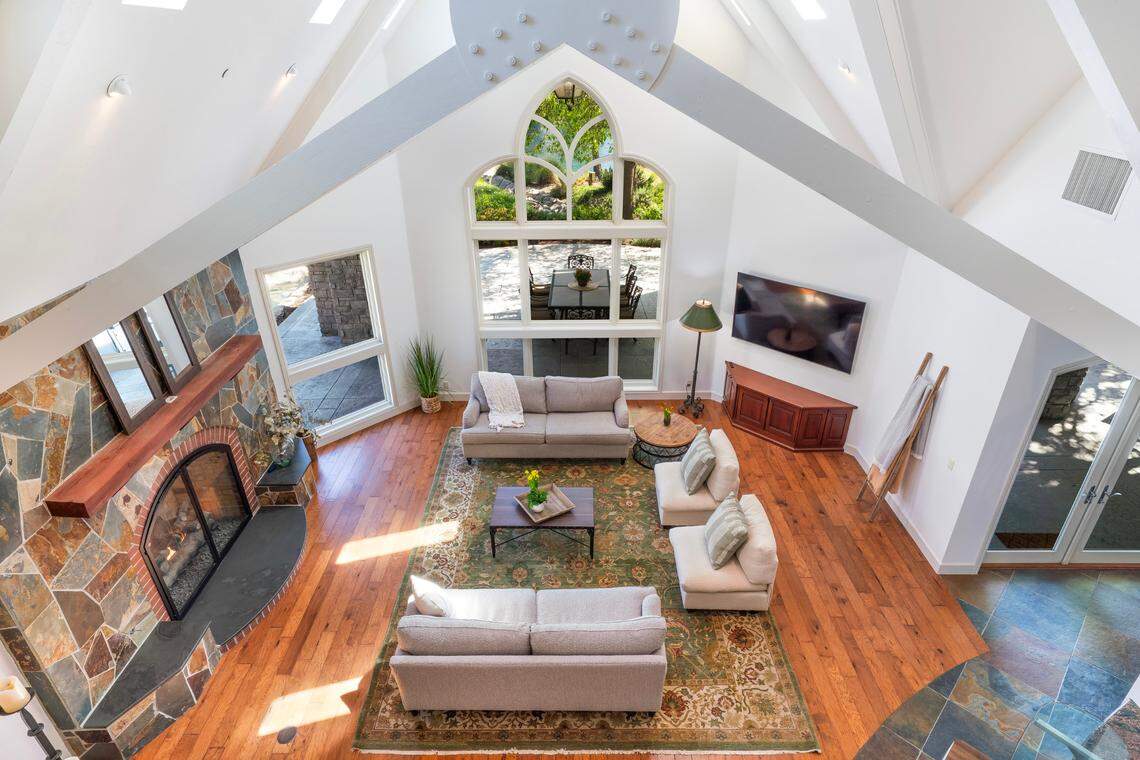 In the grand family room, a 39-foot vaulted ceiling with gorgeous wood beams soars above a large fireplace and expansive windows at the Davis, California, estate.