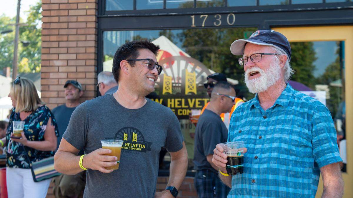 David Gull, owner of New Helvetia Brewing Company, talks with a regular Dan Allison during the Broadway International Festival in 2021. The company said escalating costs and diminishing revenue caused by the COVID-19 pandemic cast doubts on its future.