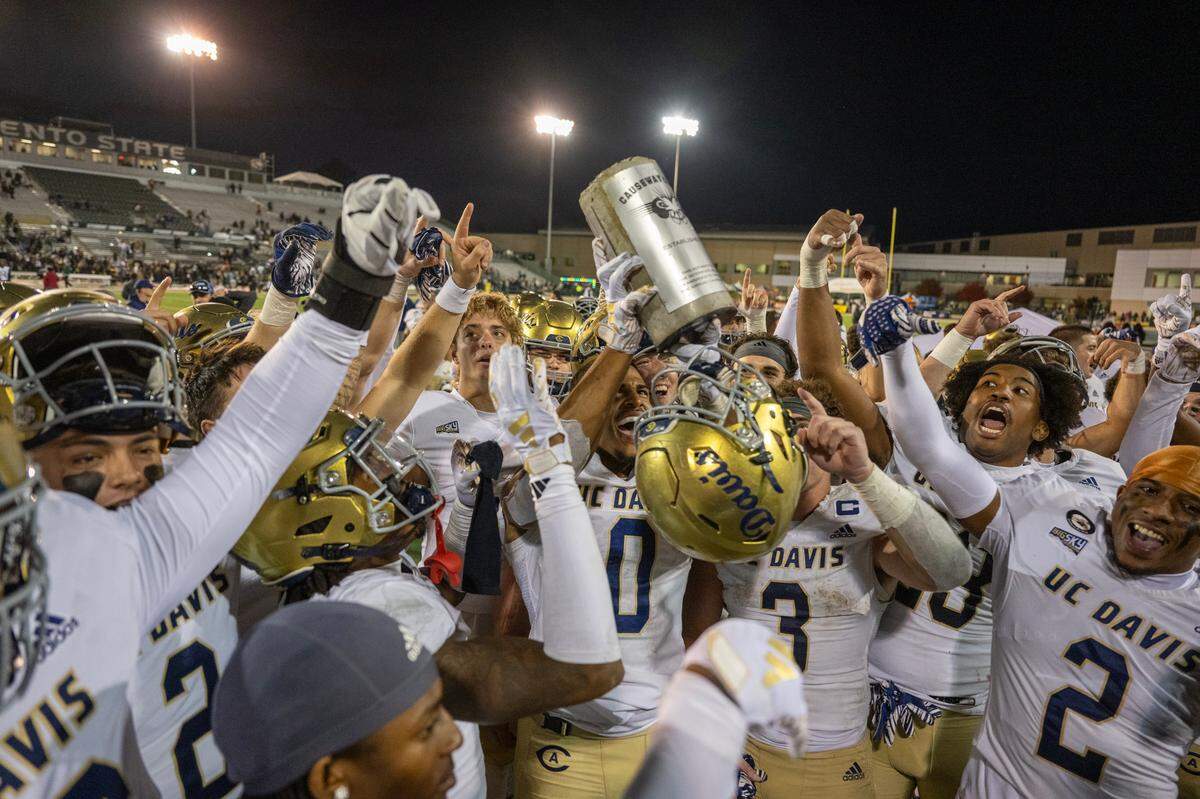 UC Davis Aggies tight end Ian Simpson (0) lifts the concrete brick trophy following the Aggies’ victory over the Sacramento State Hornets in the 70th Causeway Classic in 2024. The rivalry will go on a hiatus after the teams meet on Saturday. 