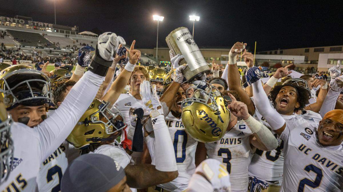 UC Davis Aggies tight end Ian Simpson (0) lifts the concrete brick trophy following the Aggies’ victory over the Sacramento State Hornets in the 70th Causeway Classic on Saturday in Sacramento.