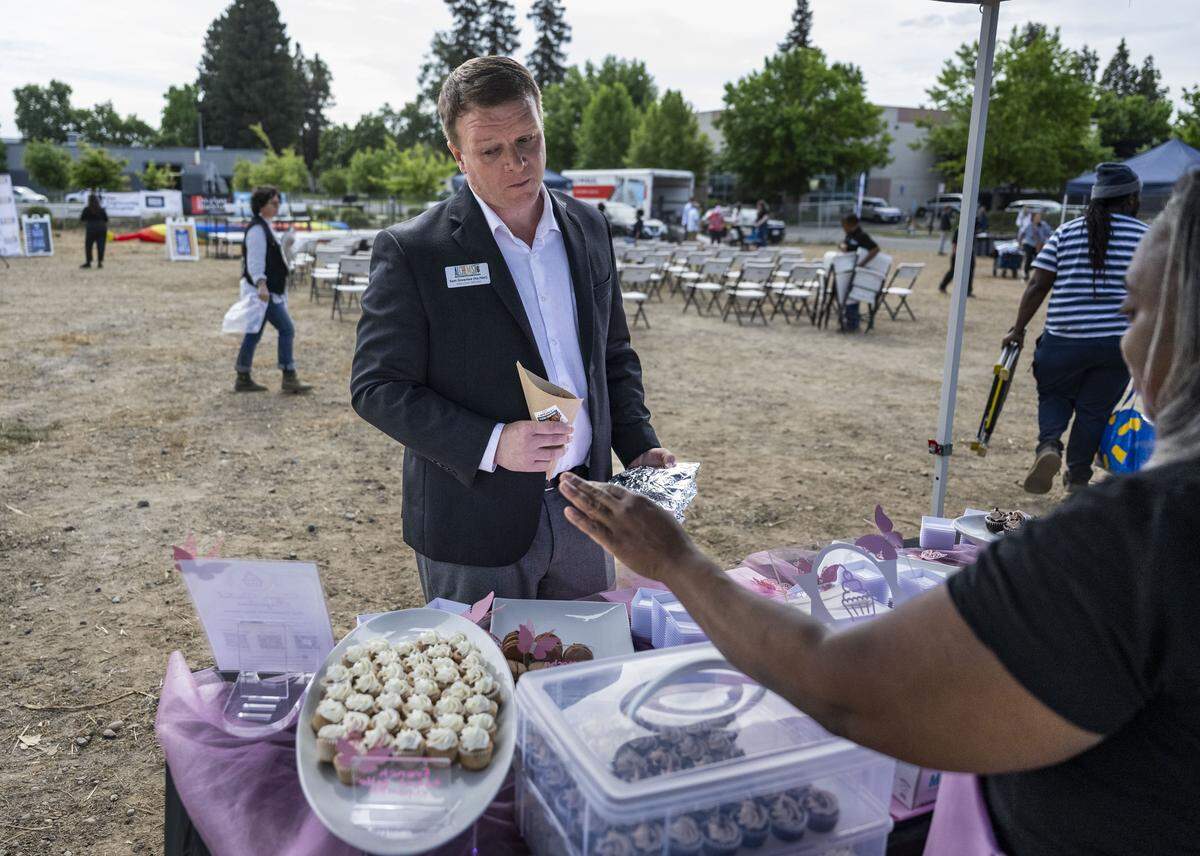 Alchemist CEO Sam Greenlee visits the stand of LaQueanya Henry, a Sacramento resident who owns Sugar Coated Cupcakes, a gourmet cupcake company, during the  groundbreaking of Alchemist Public Market in Sacramento’s River District on Thursday.