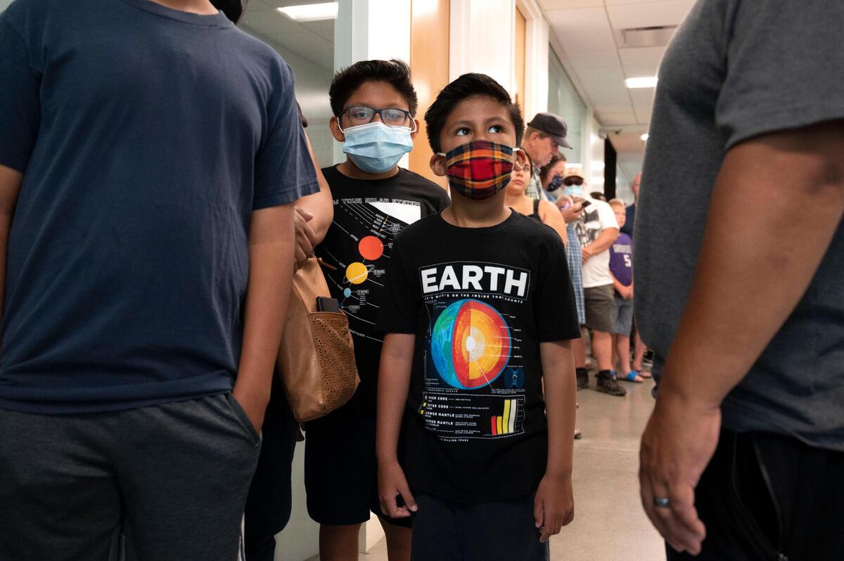 Alexandro Lopez, 9, left, and his brother David, 6, wait in line Tuesday as they prepare to enter the Sacramento State Planetarium to get get a first look of dramatic and unprecedented images of the universe taken by the new James Webb Space Telescope.