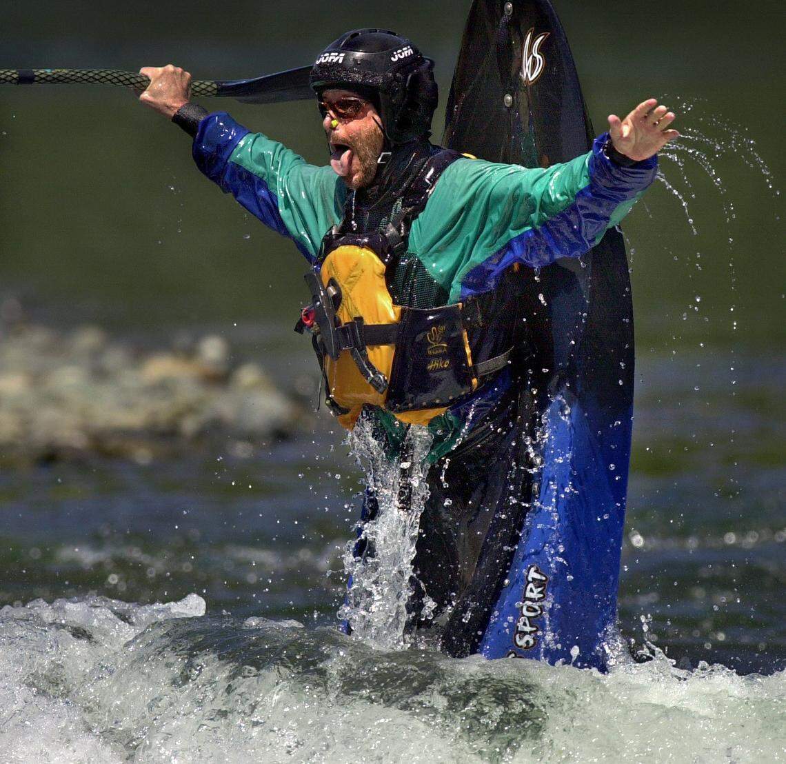 Jonas Minton of Sacramento, a kayaker for 25 years, sticks out his tongue while completing a difficult maneuver in his kayak at the San Juan Rapids along the lower American River below the Sunrise Bridge in August 2001.