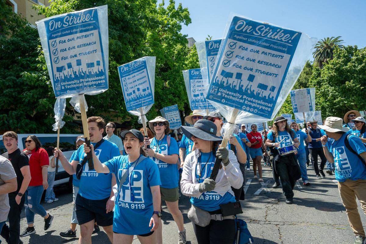 Several hundred University of California health care, research and technical workers walk down 16th Street in Sacramento during a one-day strike alleging unfair labor practices for May Day.