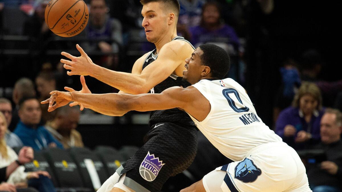 Sacramento Kings guard Bogdan Bogdanovic (8) and Memphis Grizzlies guard De’Anthony Melton (0) battle fr the ball during game at Golden 1 Center on Thursday, Jan 2, 2020 in Sacramento.