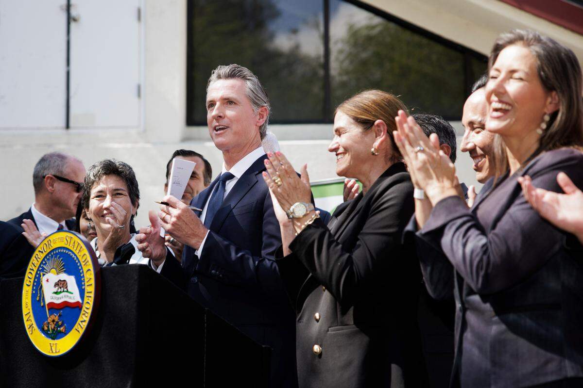 Gov. Gavin Newsom signs legislation establishing the Community Assistance, Recovery and Empowerment Act, in San Jose on Wednesday. The CARE program allows family members, first responders and others to ask a judge to draw up a treatment plan for someone diagnosed with certain disorders, including schizophrenia.