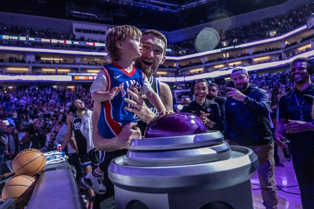 Sacramento Kings center Domantas Sabonis (11) helps his son Tiger light the beam after the team’s 109-98 win against the Phoenix Suns during an NBA game at Golden 1 Center on April 13, 2025. 