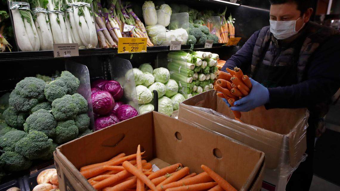 A grocery worker in San Francisco in 2020. Front-line grocery workers could benefit from a pilot federal grant program.