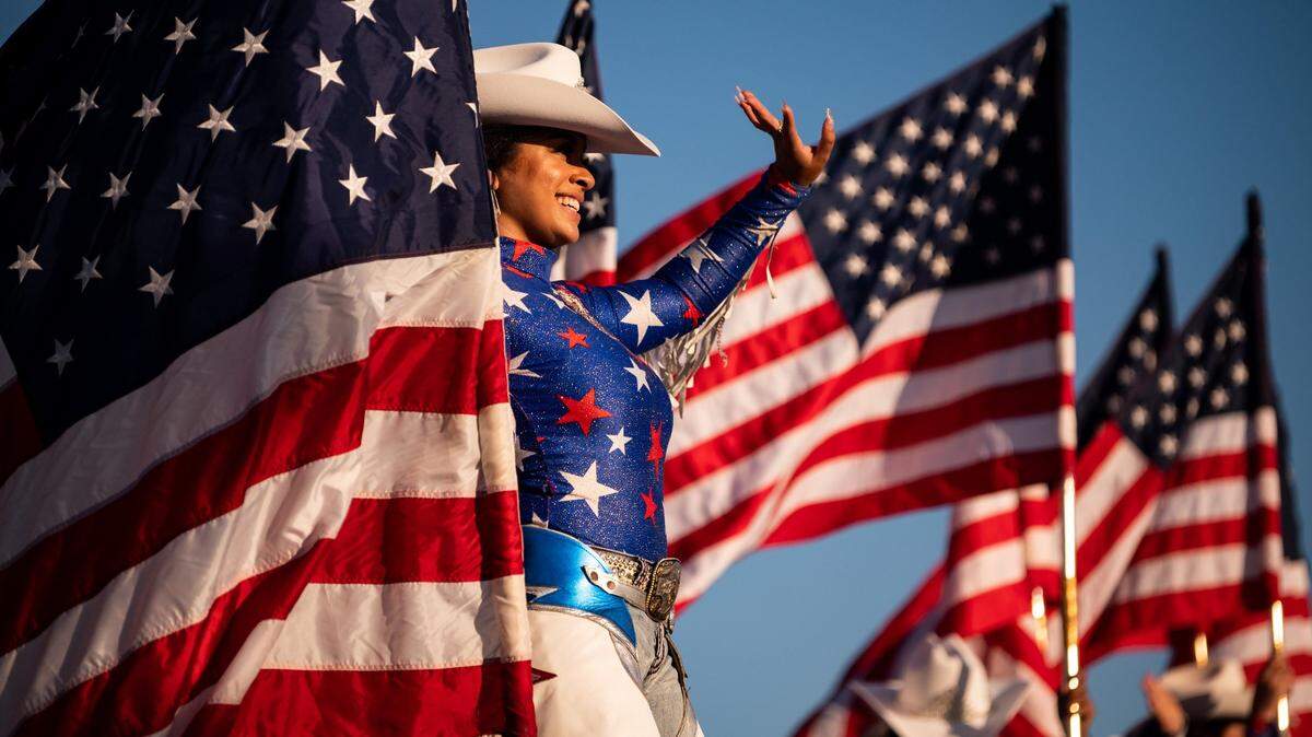 Painted Ladies rodeo performer Jade Sweeney, of Sacramento, stands on a horse named Cody while greeting people arriving to the Star Spangled Drive In Independence Day event, presented by Folsom businesses and organizations, on Friday, July 3, 2020, south of Highway 50 in the planned Folsom Ranch community. Tickets were sold out in advance, limiting attendance for the event, which was advertised as a socially-distanced and safe evening celebrating the community and nation with interactive entertainment ending with a fireworks show.