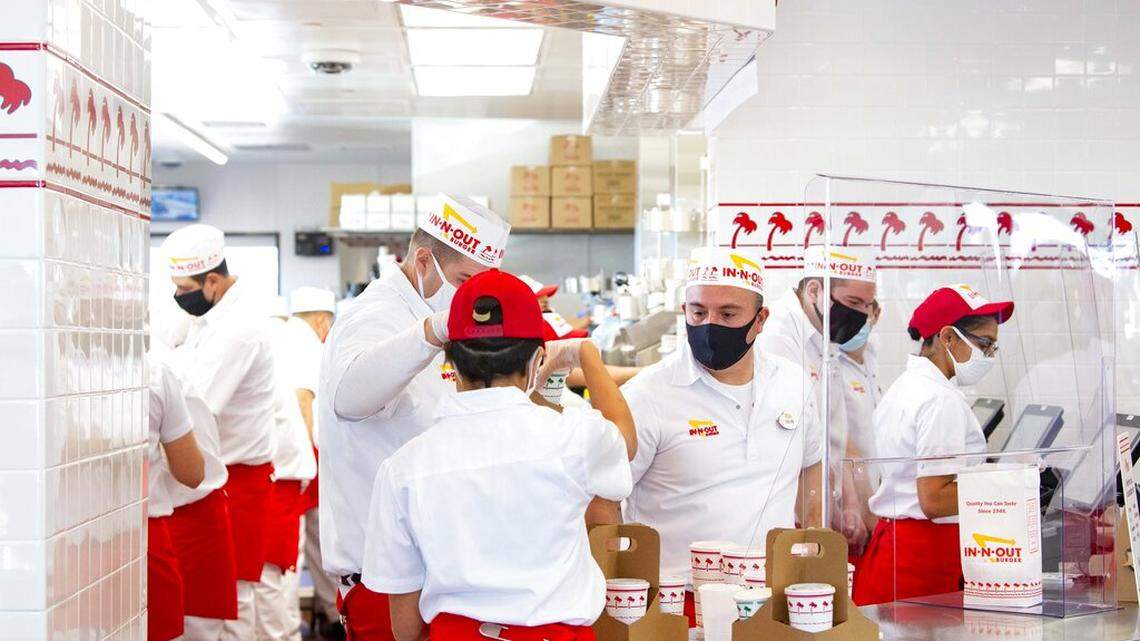 Employees hustle to keep up with the orders at the Colorado Springs In-N-Out restaurant Friday, Nov. 20, 2020. The first two locations in Colorado opened Friday, this one at the southeast corner of InterQuest and Voyager parkways and one in Aurora. (Christian Murdock/The Gazette via AP)