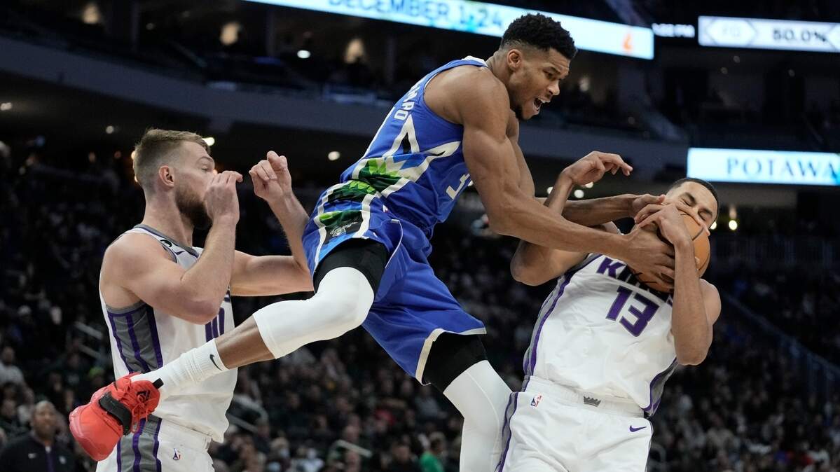 Milwaukee Bucks’ Giannis Antetokounmpo and Sacramento Kings’ Keegan Murray go after a loose ball during the second half of an NBA basketball game Wednesday, Dec. 7, 2022, in Milwaukee. (AP Photo/Morry Gash)