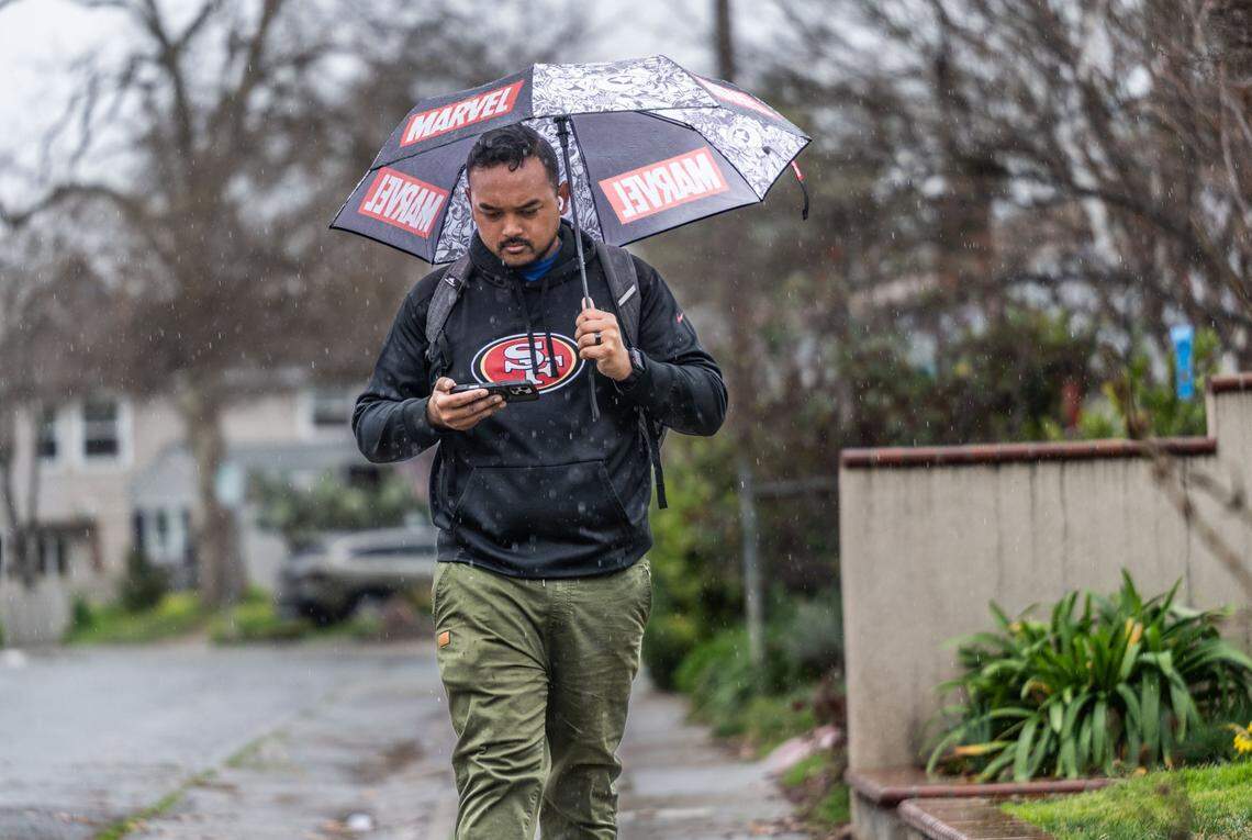 Sophiep Suos, of Oak Park, carries an umbrella as he walks in the rain to work on Feb. 19, 2025.