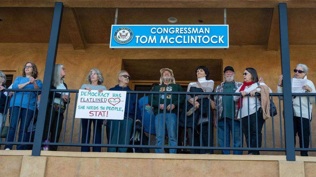 El Dorado Hill resident Gina Abrams, part of the leadership team for Indivisible El Dorado, holds a sign that says “Democracy has flatlined” at Congressman Tom McClintock’s office in El Dorado Hills Town Center on Friday, Feb.21, 2025, as she joins a protest against President Donald Trump and his adviser Elon Musk.