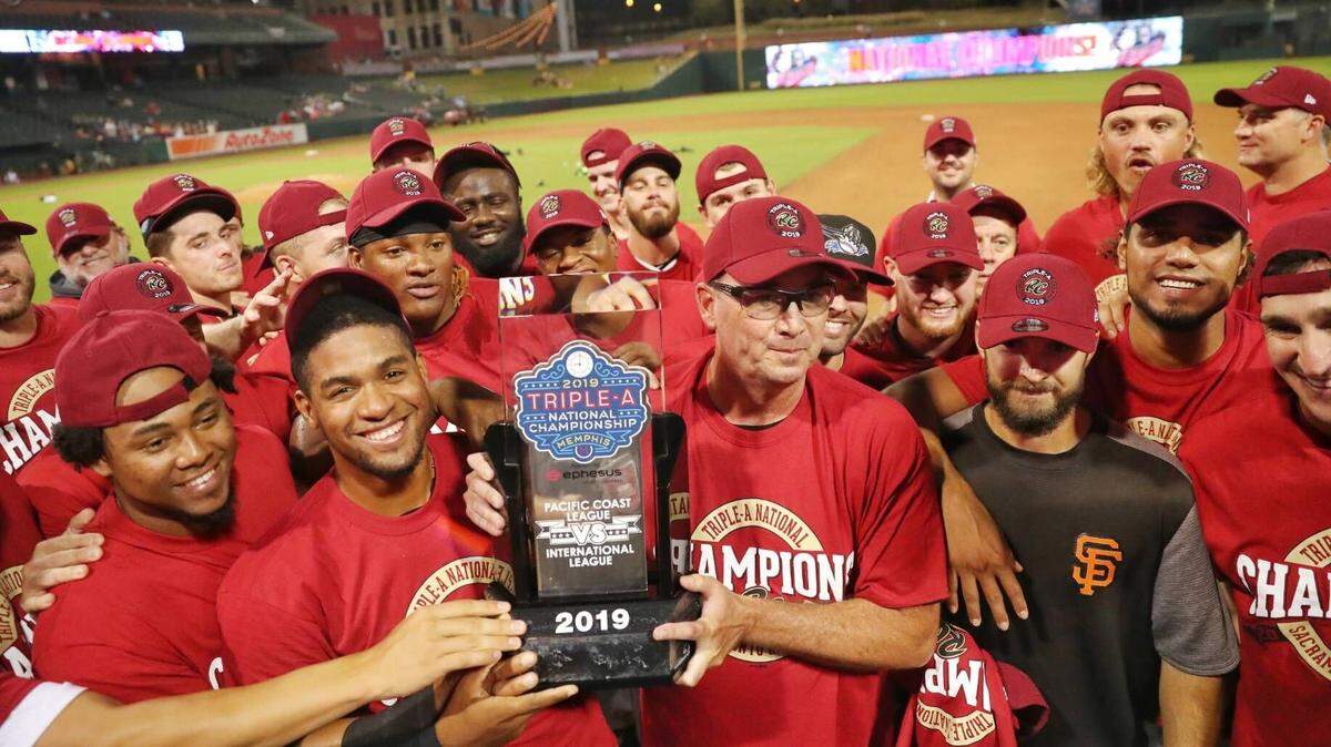 River Cats manager Dave Brundage, center, helps hoist the Triple-A National Championship trophy as he’s surrounded by by the team following Sacramento’s 4-0 victory over the Columbus Clippers on Sept. 17, 2019, in Memphis, Tenn.