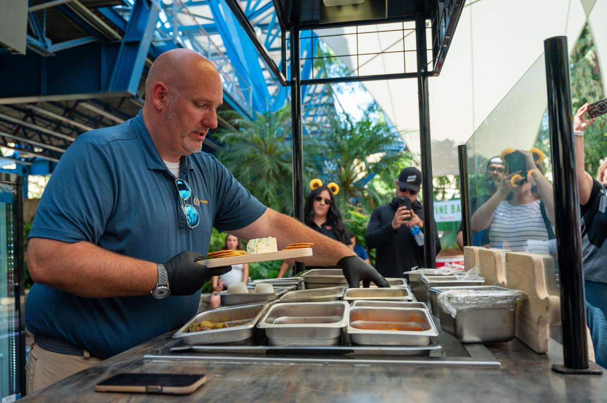 Corey Brandt, district general manager of Oak View Group, demonstrates how fair goers can create custom charcuterie boards at the California State Fair on Wednesday.