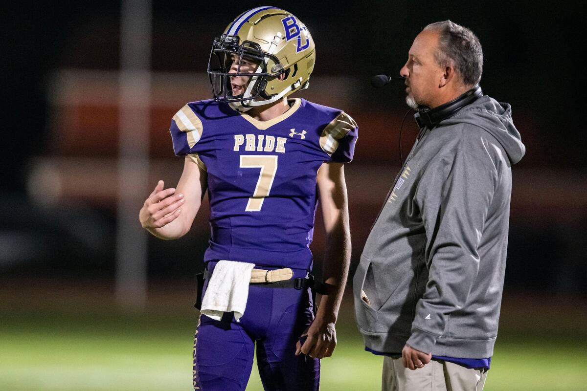 Bradshaw Christian quarterback Ethan Rickert (7) talks with head coach, and father, Drew Rickert as they play in a CIF Sac-Joaquin Section Division VI high school football playoff game against Delhi in 2022.