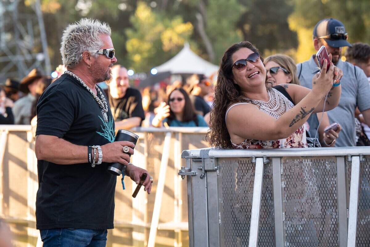 Celebrity television personality and restauranteur Guy Fieri poses for a selfie with a fellow attendee at Sacramento’s first-ever GoldenSky country music festival Saturday, Oct. 15, 2022, at Discovery Park. The two-day event featured headliners Tim McGraw and Sam Hunt, as well as Brothers Osborne, Midland, Carly Pearce and more.