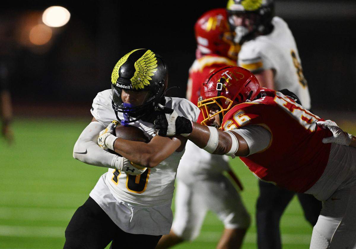The Del Oro Golden Eagles' Brandon Alfonso (16) is tackled by the Jesuit Marauders' Lolo Mabalot (66) In the second half on Friday, Oct. 17, 2025, in Carmichael.