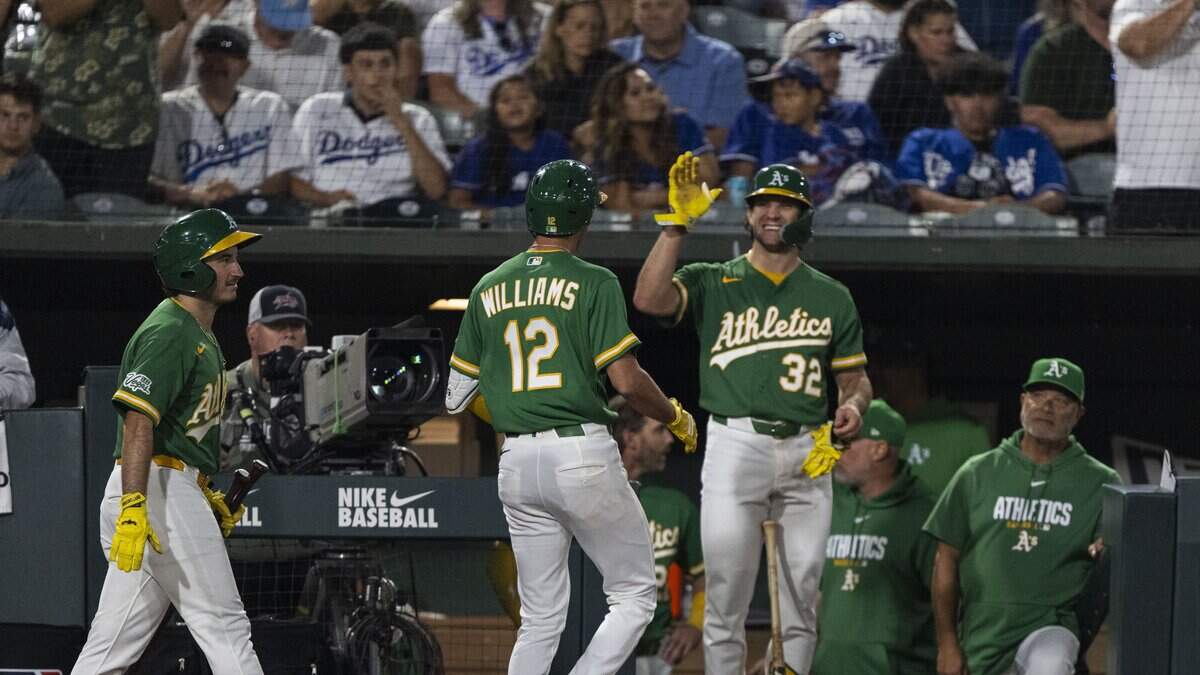 Athletics infielder Alika Williams (12) is celebrated by teammate Colby Thomas (32) after Williams hit a home run in the eighth inning against the Los Angeles Dodgers at Sutter Health Park in West Sacramento on Wednesday.