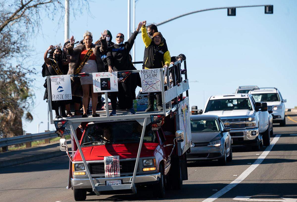 A truck carries a platform filled with people celebrating Martin Luther King Jr. Day as part of a #ReclaimMLK Day car caravan on Monday, Jan. 18, 2021 in Sacramento.