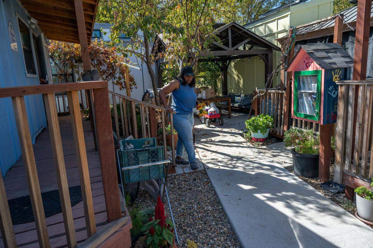 Robin Moore, 61, walks through the Safe Harbor tiny home community in her backyard earlier this month. She works with Family Promise to run the shelter. “Homelessness isn’t us or them, it’s just all of us — some of us are there, some of us are a paycheck away, some of us are a medical event away, some of us are domestic violence event away,” she said. “it is something that can touch everyone.”