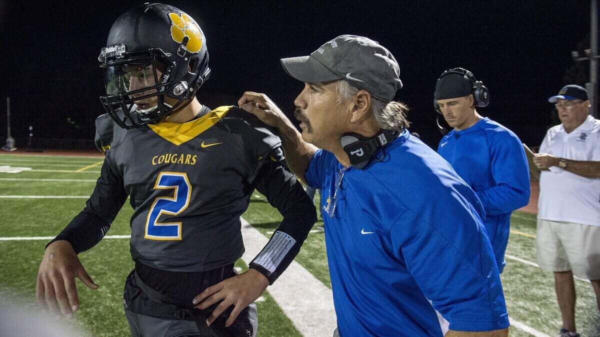 Coach Mike Dimino, a retired CHP officer, gives his son, quarterback Tyler Dimino, instruction in the first quarter as Del Campo hosts Oakmont on Oct. 26, 2017.
