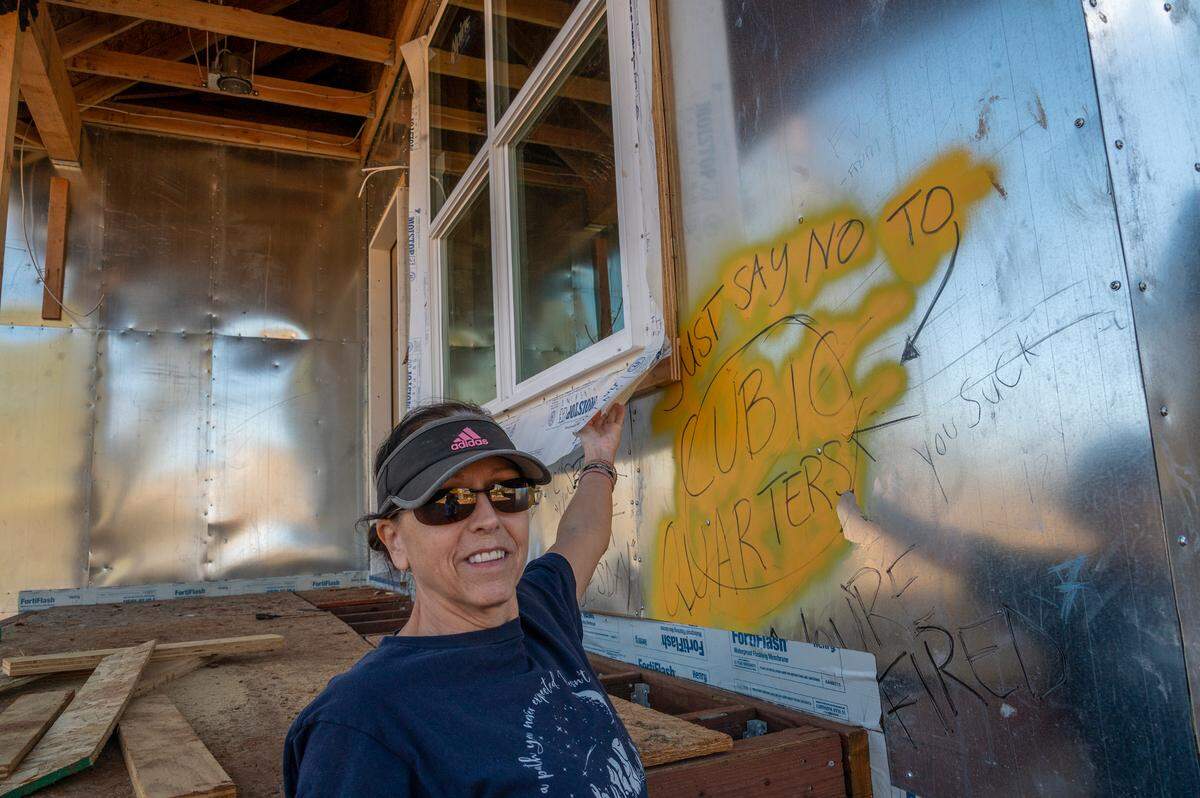 Camp Fire victim Sharon O’hara in March shows off a message to “just say no” to Cubic Quarters that she highlighted on the front of her unfinished home in Paradise. “Who can do this to people and not have a conscience?” she said, when talking about Tricia Cohen, the owner of Cubic Quarters.