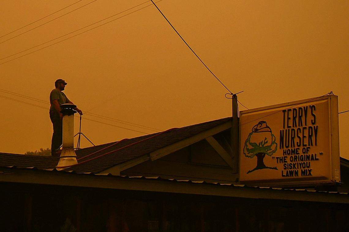 Dustin Brown waters the roof using a sprinkler at his fathers business on Highway 263 near Montague Road as the McKinney Fire burns in Klamath National Forest in Siskiyou County on Sunday. “I’m not losing this,” said Browns father. “I’ve owned it for 46 years.”